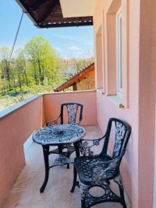 einen Tisch und zwei Stühle auf dem Balkon in der Unterkunft Apartman Kula in Gradačac