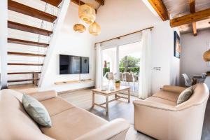 a living room with a couch and a tv at Villa Ingrid in Cala en Forcat