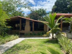 a house with a palm tree in front of it at Chacara Maluco Beleza 2 in Gravatá