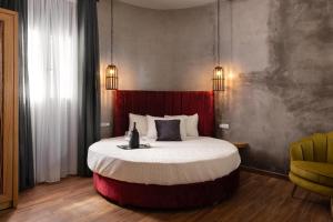 a bedroom with a large bed with a red headboard at Zoe Suites in Rhodes Town