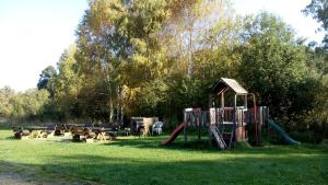 a park with a playground with a slide and benches at Apartmán PECKA - Nová Pec in Nová Pec