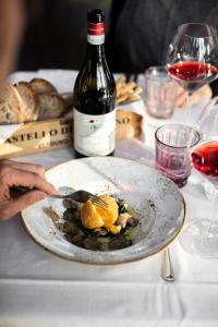 un plato de comida en una mesa con una botella de vino en Cà del Re, en Verduno