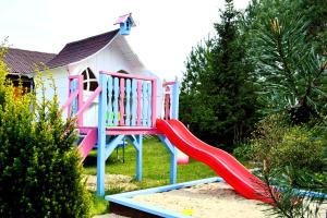 a playground with a slide in front of a house at Ośrodek Daglezja in Kołczewo