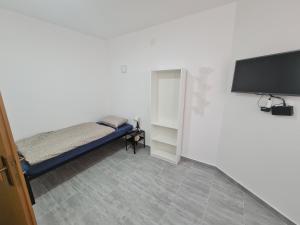 a small bedroom with a bed and a tv at Budget Apartment LeLo Centar2 in Osijek