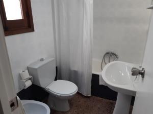 een witte badkamer met een toilet en een wastafel bij Hotel Azahar in Oliva