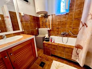 een badkamer met een wastafel en een bad bij Francia Ház in Balatonföldvár