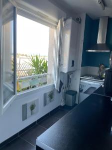 フュリアニにあるAppartement Cosy et spacieux, avec balcon et vue sur la merのキッチン(海の景色を望む窓付)