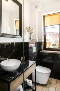a bathroom with a sink and a toilet and a mirror at Kamienica Portowa in Mikołajki +39 photos