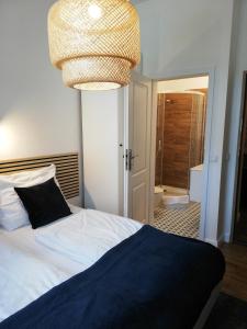 una camera da letto con un letto e un lampadario di Rooms by Apartamenty Lubartowska Street a Lublino