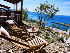 a patio with two chairs and a table and the ocean at Mobile Home FantaSea in Novi Vinodolski
