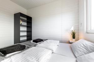 2 camas en una habitación con paredes blancas en New Wave Resort Mielno en Mielno