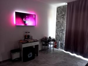Ca Bianca的住宿－La Famiglia Doppia，一间墙上配有电视和桌子的房间