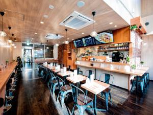 a restaurant with tables and chairs and a bar at HOTEL LiVEMAX Fukuoka Tenjin West in Fukuoka