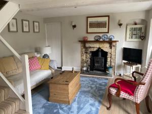 a living room with a couch and a fireplace at The Garden Cottage in Stroud