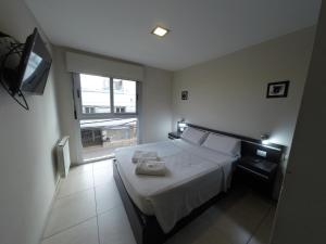 a bedroom with a bed with a television and a window at Departamentos Nubes - Salta Capital in Salta