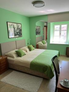 um quarto com uma cama grande e paredes verdes em Rooms Toni Palace em Split