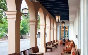a row of wooden tables with chairs and umbrellas at Hotel St Francis in Santa Fe
