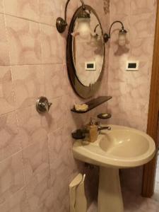 een badkamer met een wastafel en een spiegel bij B&B GENOVA COUNTRY in Fegino