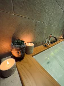 a bathroom with candles and a sink and a bath tub at Eden Room&Spa in Torremaggiore