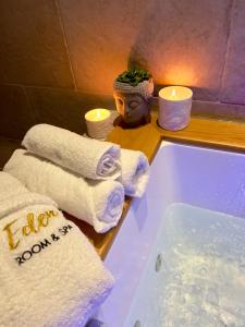 a bathroom with towels and a bath tub with candles at Eden Room&Spa in Torre Maggiore