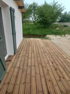 a wooden deck outside of a house at Une petite maison et sa prairie in Villefargeau