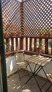 un banco y una silla en un balcón con macetas en Tzefania Hotel en Jerusalén