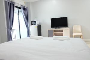 a bedroom with a large bed and a tv at Order Residence in Ban Pa Muat