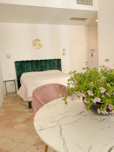 B&B Faraglione في ليباري: غرفة نوم بسرير وطاولة وزهور