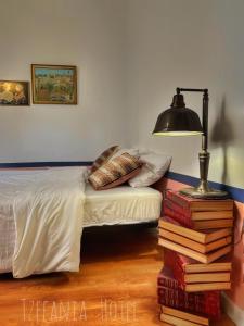 um quarto com uma cama e uma pilha de livros em Tzefania Hotel em Jerusalém