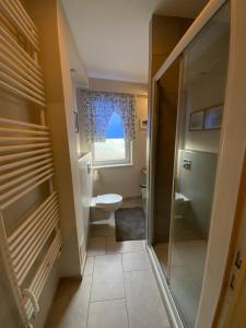 a small bathroom with a toilet and a window at Apartament Stella Maris in Puck