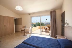 a bedroom with a blue bed and a balcony at Makronisos Village in Ayia Napa +37 photos