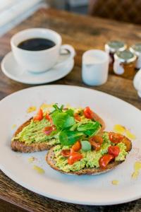 ein weißer Teller mit einem Stück Toast mit Gemüse und einer Tasse Kaffee in der Unterkunft Rowntree Lodge in Scarborough