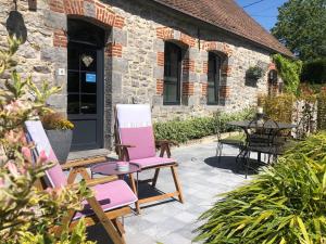 un patio con 2 sillas y una mesa en Le Relais du Biau Ri en famille ou entre amis, en Clairfayts