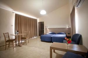 a hotel room with a bed and a table and chairs at Makronisos Village in Ayia Napa