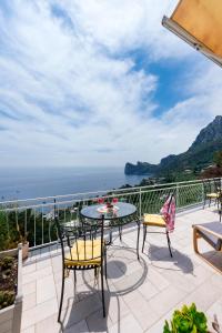un patio con tavolo, sedie e vista sull'oceano di Belvedere apartament stunning sea view a Nerano