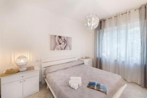 una camera bianca con un letto e una finestra di Belvedere apartament stunning sea view a Nerano