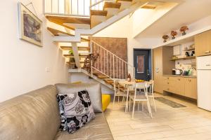 a kitchen and living room with a couch and a staircase at Nuriel Fruit & Guest House in Sheʼar Yashuv