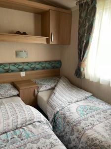 two beds in a small room with a window at 24 Glenfinart Park in Dunoon