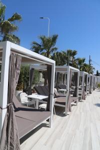 a row of chaise lounge chairs on the beach at Hotel Villa Pascucci in Durrës