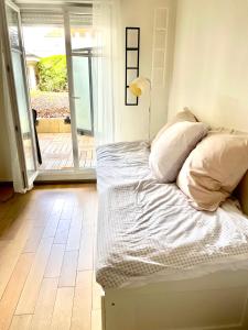 a bed with white sheets and pillows in a room at Studio Disneyland Paris 2 - Terrasse in Bussy-Saint-Georges