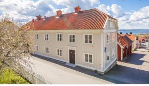 uma grande casa branca com um telhado vermelho em Ångbåten - New buildt apartment in the center of Gränna em Gränna