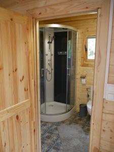 a bathroom with a shower in a wooden cabin at Domek letniskowy drewniany nad Jeziorem Strzeszowskim nowy in Strzeszów