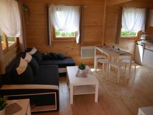 a living room with a couch and a table at Domek letniskowy drewniany nad Jeziorem Strzeszowskim nowy in Strzeszów
