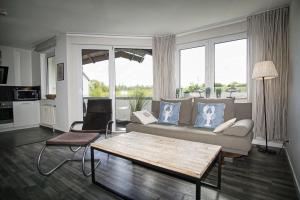 ein Wohnzimmer mit Sofa und Tisch in der Unterkunft strandnah mit Balkon, gratis Nutzung vom AHOI Erlebnisbad und Sauna in Sellin - Strandhaus Mönchgut FeWo11 in Lobbe