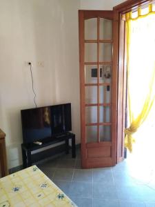 salon z drzwiami, telewizorem i stołem w obiekcie LA Casina di Anna w mieście Menfi
