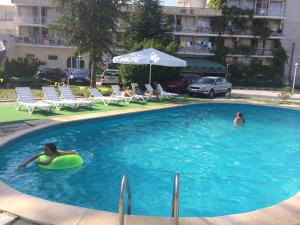 two people in a swimming pool with a green ball in the water at DSK Hotel in Kranevo
