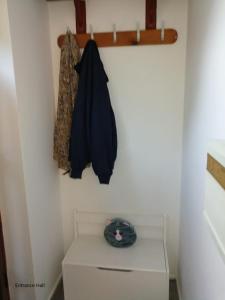 a room with a white cabinet and a coat hanging on a wall at City centre apartment with south facing patio close to the harbour in Plymouth