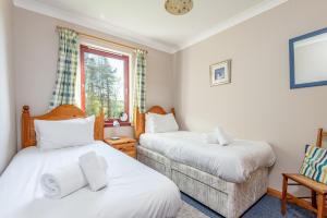 - une chambre avec 2 lits et une fenêtre dans l'établissement The Old Mill Cottage - 10 Mins to St Andrews, à St Andrews