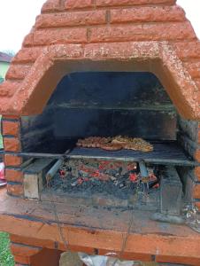 um forno de tijolos com comida a cozinhar num grelhador em Cookies Old House Visoko em Visoko