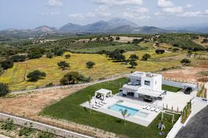 una vista aérea de una casa blanca con piscina en Alma Villa, 2000m2 Luxury Living, by ThinkVilla, en Angeliana